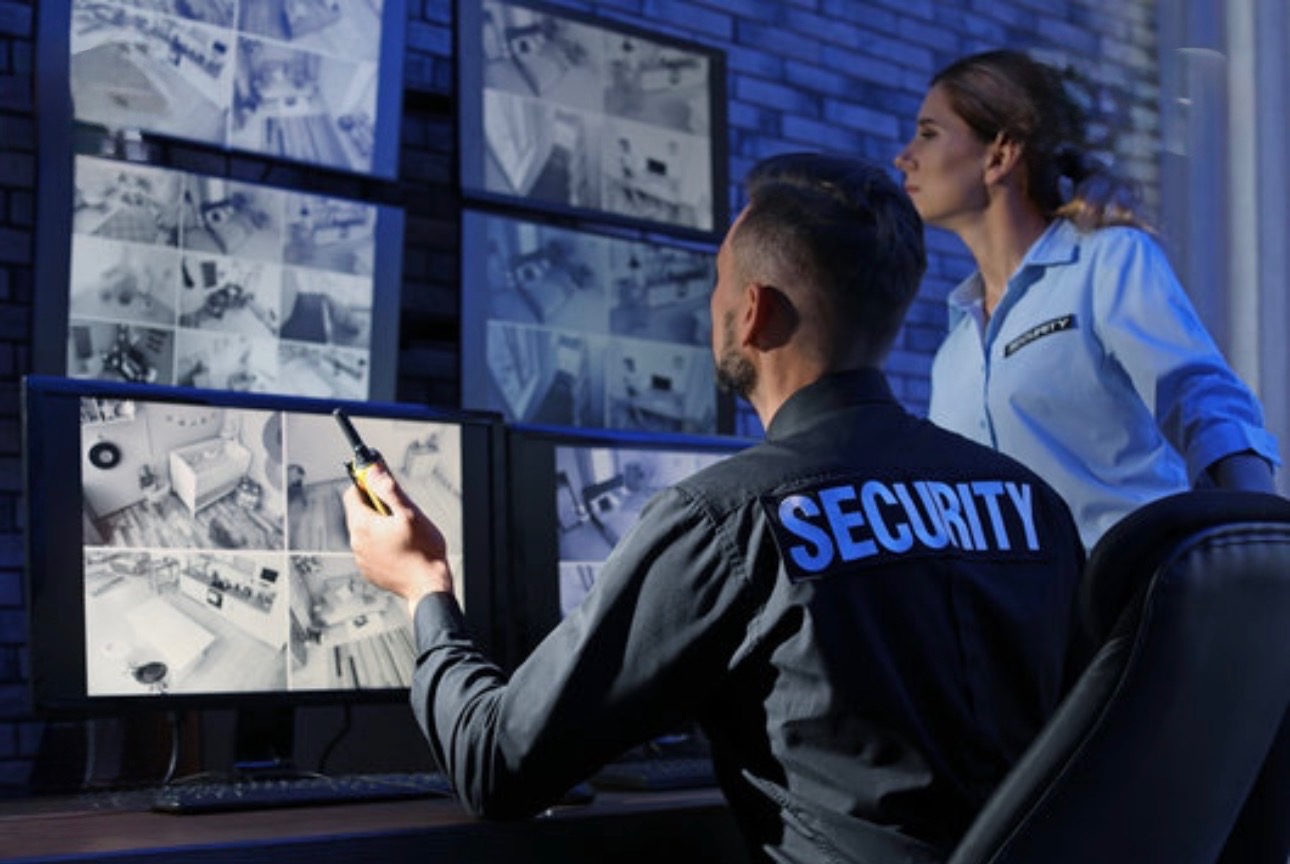 Security officers monitoring surveillance camera feeds in a command center